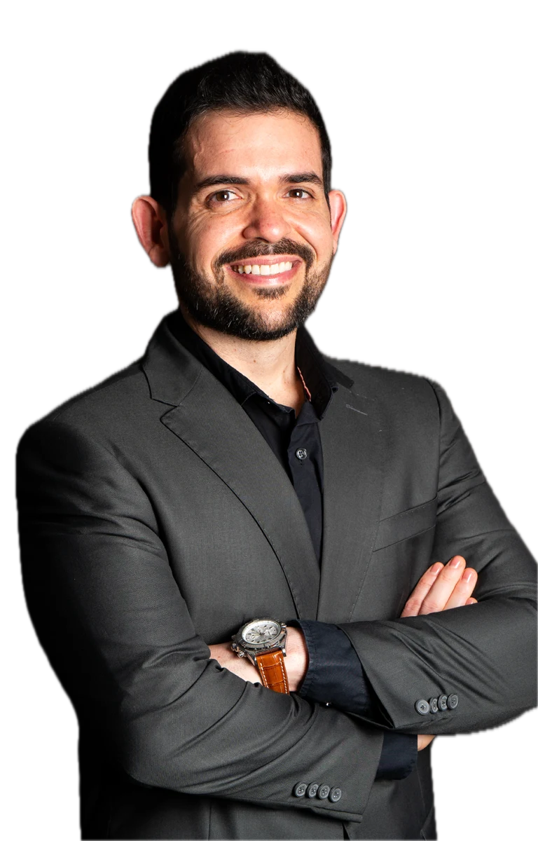 Igor Caleb sorrindo, de braços cruzados e usando terno escuro